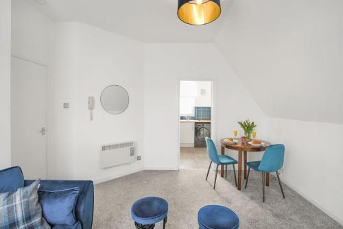 阿洛厄Myreton Hill Apartment的客厅配有桌子和蓝色椅子