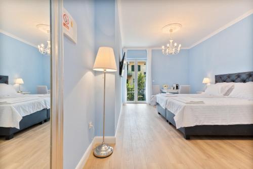 斯普利特Leonilda Rooms的一间蓝色卧室,配有两张床和一盏灯