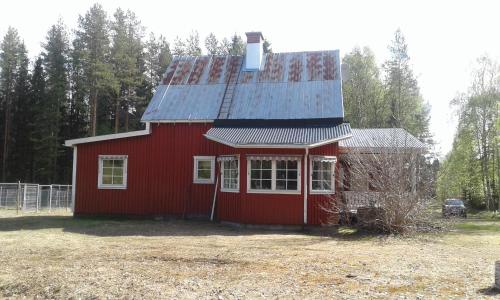 ÖverkalixVilla Polarktis的一座红色的房子,上面有锡屋顶