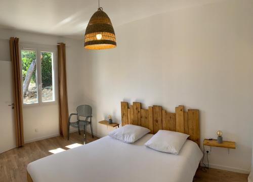勒拉旺杜Le Rossignol 2, Aiguebelle plage Le Lavandou的卧室配有白色的床和吊灯