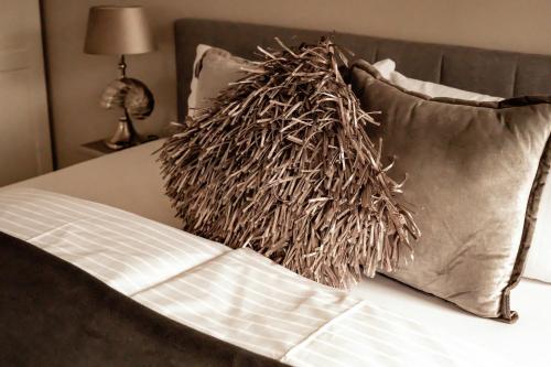 韦斯特兰Boutique Hotel Villa Monika的枕头旁边的床上的枕头堆