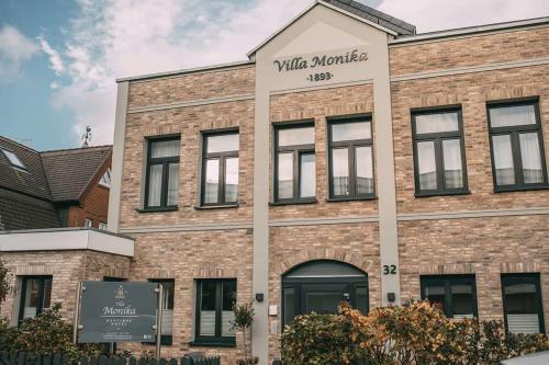 韦斯特兰Boutique Hotel Villa Monika的带有读写马里奥特的标志的砖砌建筑