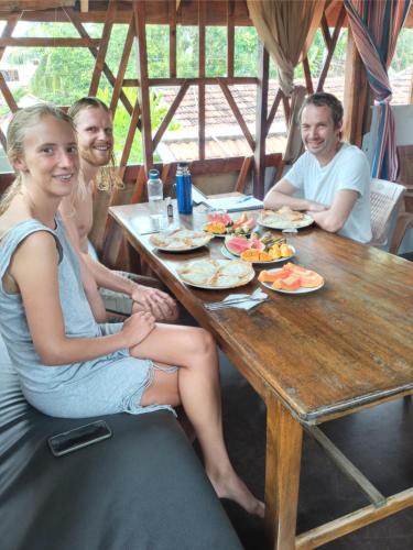 阿鲁甘湾Beach Cab Resort的一群坐在餐桌上吃食物的人