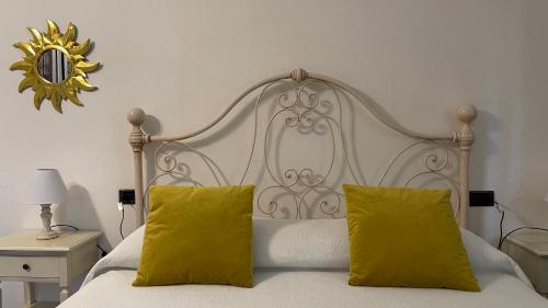 圣吉米纳诺Podere Montese Country House的卧室配有白色床和2个黄色枕头
