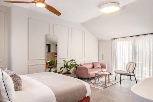 耶路撒冷Albi Boutique Hotel - Traveler's Choice 2024的一间卧室配有一张大床和一张粉红色的椅子
