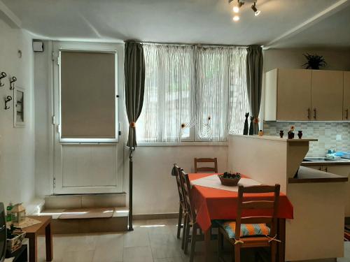 KonizopíQuiet, colourful home in Cyclades的厨房以及带红色桌椅的用餐室。
