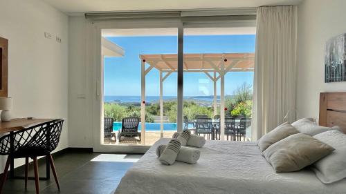 蓬塔格罗萨Villas Tin Coves Noves的一间卧室配有一张床,享有游泳池的景色