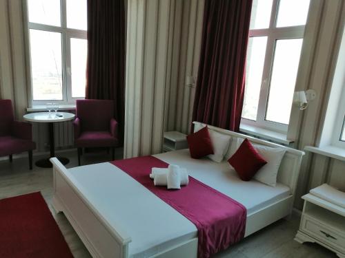 阿斯塔纳Apart Hotel Триумф Астаны 22 этаж, Секция 2的卧室配有白色床、红色枕头和窗户