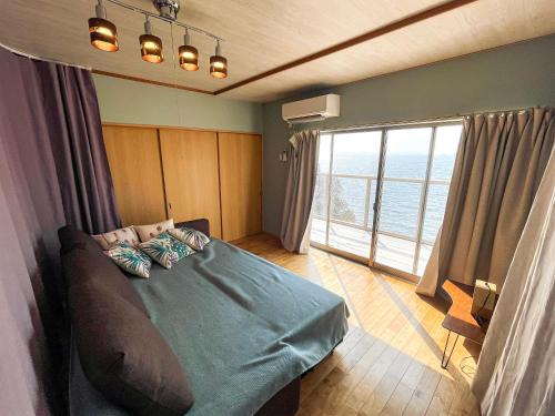 小豆岛villa chillon的一间卧室设有一张床和一个大窗户