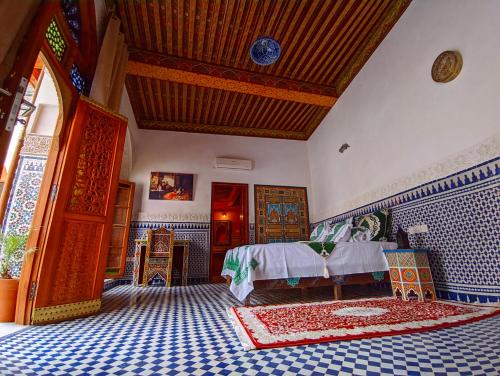非斯Riad Fès Center的卧室配有床和蓝色及白色瓷砖