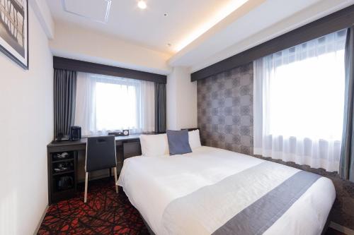 名古屋名古屋锦酒店阿科特尔酒店的酒店客房设有一张床、一张书桌和窗户。