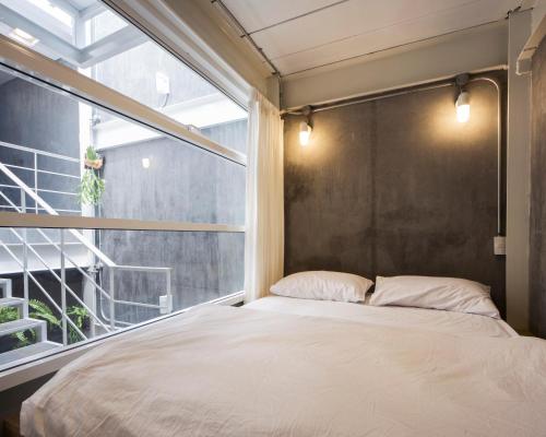 曼谷床上旅馆的一间卧室设有一张床和一个窗口