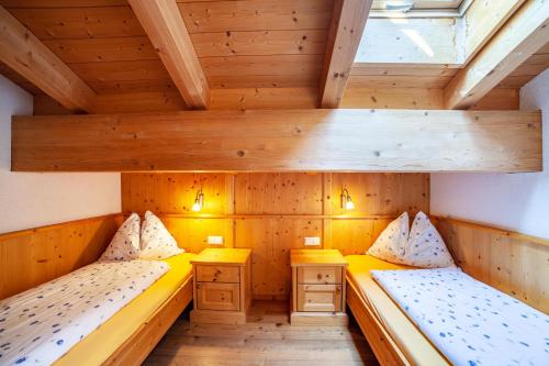 MontechiaroHof am Schloss Apartement Zirm的小型客房设有两张带木制天花板的床。