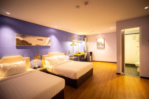 乔治市Le Embassy Hotel Georgetown的一间卧室设有两张床和紫色墙壁