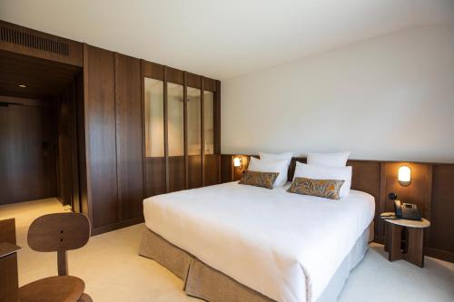 维琪奥港Hôtel Spa & Restaurant - Son de Mar的卧室设有白色大床和木墙