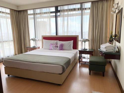 吉隆坡Universal Times Suites At Times Square的一间卧室配有一张大床和两个紫色枕头