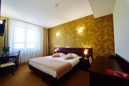 苏瓦乌基西兹科酒店的酒店客房设有一张大床和一张书桌。