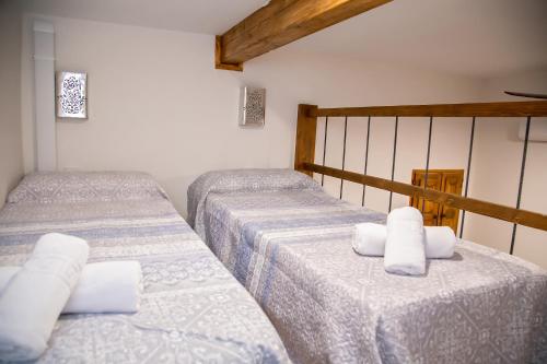 阿利坎特LA CASA MORISCA的配有白色床单的客房内的两张单人床