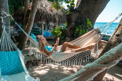 特贾库拉慈利艾玛斯海滨度假村的躺在海滩上吊床上的女人