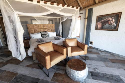 塞斯瑞姆Desert Homestead Lodge的一间卧室配有一张床和两把椅子