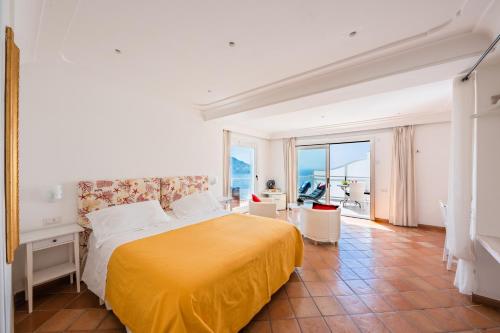 波西塔诺安费特莱特别墅的一间卧室设有一张黄色的床和一个阳台