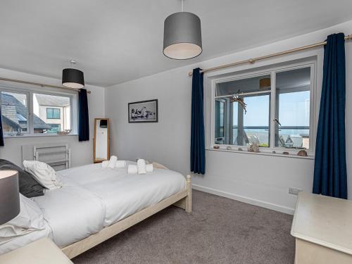 罗斯奈格尔Pass the Keys Sea View Apartment in centre of Rhosneigr的一间卧室设有一张床和两个窗户。