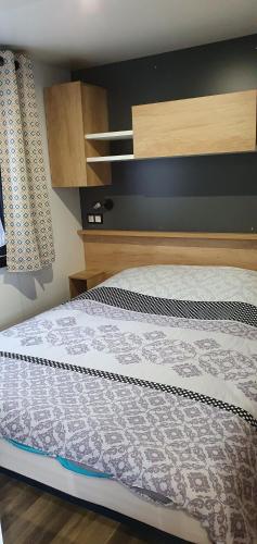 波讷地区圣朱利安Les Dunes de Contis的卧室内的一张床位,配有木制床头板