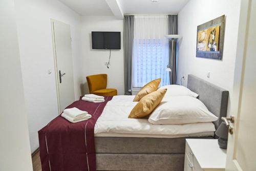 贝格卡门Hotel Kronenkurve的一间卧室配有带白色床单和金色枕头的床。