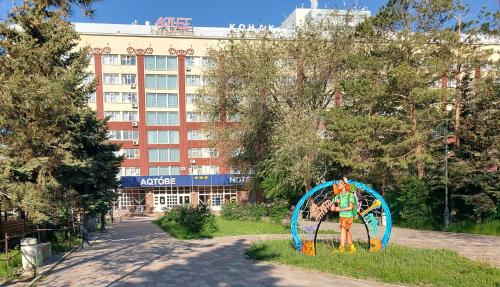 阿克托比Aktobe Hotel的建筑前草上的雕像
