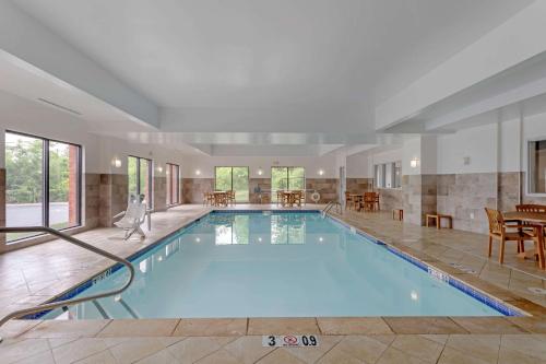 蒙特朱丽叶Comfort Suites Mt Juliet-Nashville Area的一个带桌椅的房间的大型游泳池