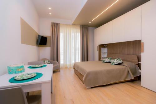莫诺波利Domina Apartments的酒店客房配有一张床铺和一张桌子。