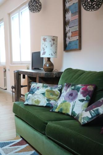 阿勒瓦尔la maison du haut de Freydon Ambiance Scandinave的客厅配有一张绿色沙发,设有一张桌子