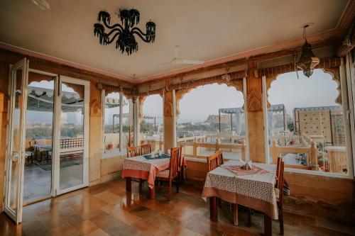 斋沙默尔古拉尔旅馆的用餐室设有桌椅和窗户。