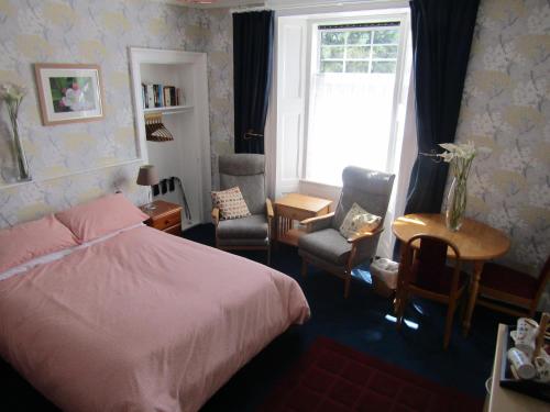 邓迪Athollbank Guest House的一间卧室配有床、椅子和窗户