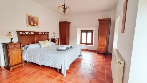San Martín de la Vega del AlbercheEl Locutorio的卧室设有一张大床,铺有瓷砖地板。