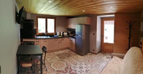 SeytrouxChalet Cathy et Michel的厨房配有沙发、桌子和冰箱。