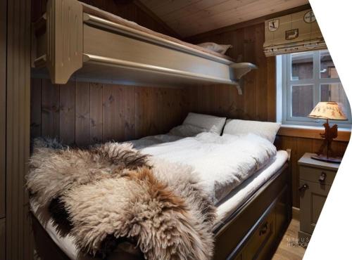 特吕西尔Beautiful cabin close to activities in Trysil, Trysilfjellet, with Sauna, 4 Bedrooms, 2 bathrooms and Wifi的一间卧室配有一张床,床上有毛绒毯子