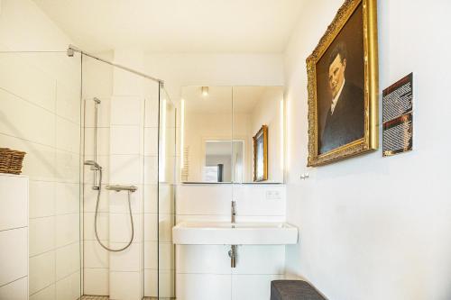 不莱梅Weserloft 16的白色的浴室设有水槽和淋浴。