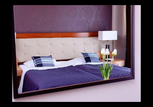奥斯特罗达Platinum Ostróda的一间卧室配有一张带镜子的紫色床
