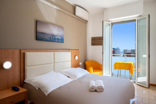 佩萨罗Amadei Hotel Figaro & Apartments的一间卧室,床上有两双白鞋