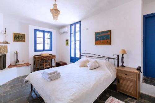 MilopótamosTraditional Village House On Kea的卧室配有一张蓝色色调的大型白色床。