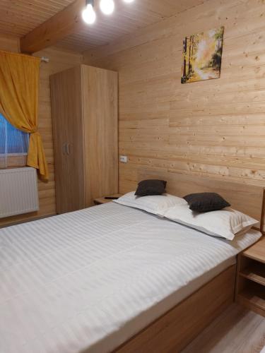 泽尔内什蒂Cabana Rustica Georgeta的木制客房内的一间卧室配有一张大床