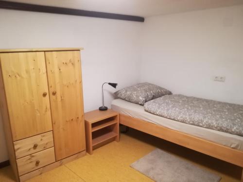 拉滕堡Ferienwohnung Martin的一间卧室配有一张床和一个木制橱柜