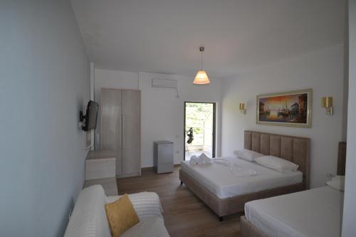希马拉Bujtina Eleni的一间卧室配有两张床和一张沙发。