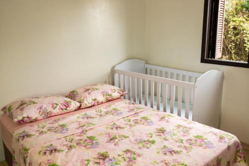 圣弗朗西斯科-迪保拉TOLEDO'S HOUSE的一间卧室配有一张带粉红色床罩和枕头的婴儿床。