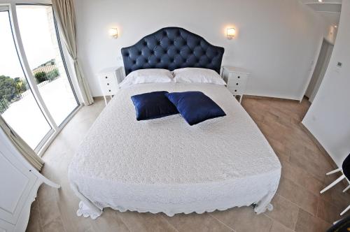 马尔扎梅米Carrua的一间卧室配有一张大床和蓝色床头板