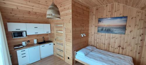 乌斯特卡Gemini MiniDomki的一间带木墙的厨房和一张位于客房内的床