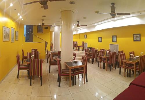 布宜诺斯艾利斯特雷斯萨根图斯酒店的拥有桌椅和黄色墙壁的餐厅