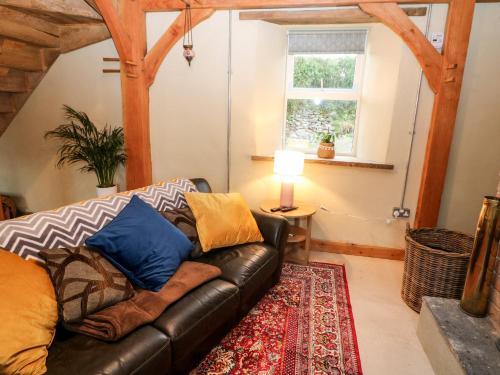 麦克鲁姆Lehane's Cottage的客厅配有真皮沙发和地毯。