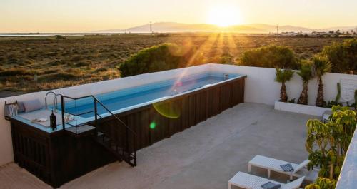 阿尔么丽亚Exclusivo cortijo con piscina privada的阳台上的热水浴池,享有沙漠日落美景